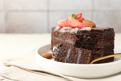 Photo of Piece of delicious chocolate cake with strawberry and almonds on table, closeup. Space for text