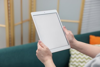 Photo of Woman with modern tablet at home, closeup