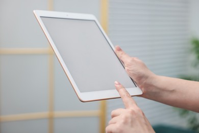 Photo of Woman with modern tablet at home, closeup