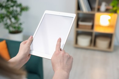 Photo of Woman with modern tablet at home, closeup. Space for text
