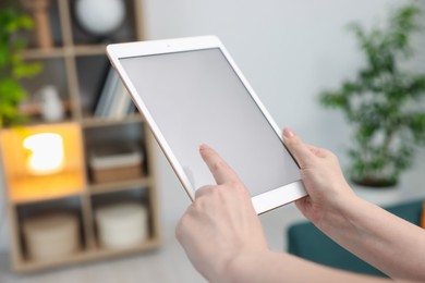 Photo of Woman with modern tablet at home, closeup