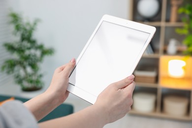 Photo of Woman with modern tablet at home, closeup