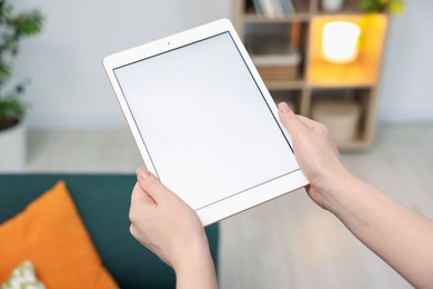 Photo of Woman with modern tablet at home, closeup