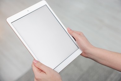 Photo of Woman with modern tablet at home, closeup