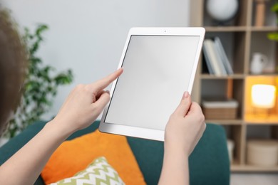 Photo of Woman with modern tablet at home, closeup