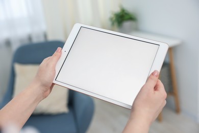 Photo of Woman with modern tablet at home, closeup