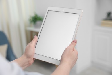 Photo of Woman with modern tablet at home, closeup