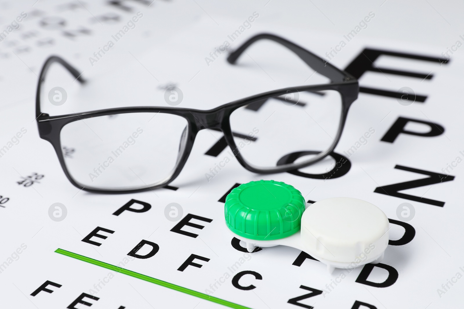 Glasses and lenses on vision test chart, closeup Photo of Glasses and lenses on vision test chart, closeup