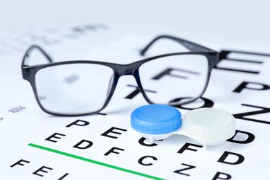 Photo of Glasses and lenses on vision test chart, closeup