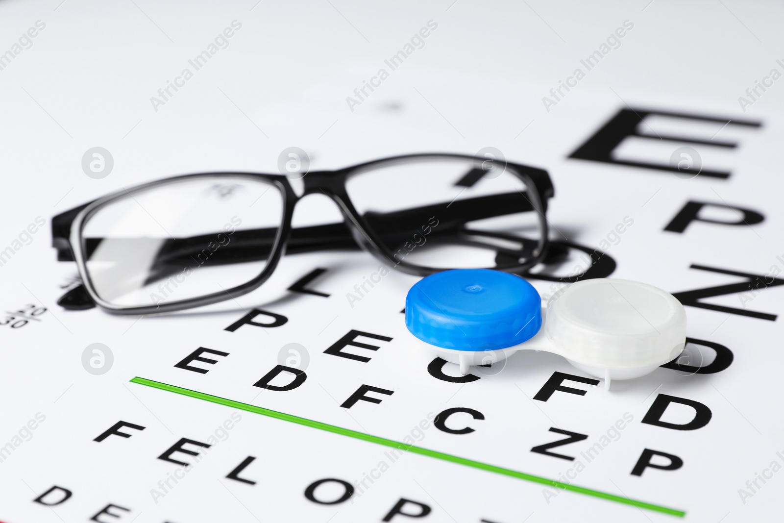 Glasses and lenses on vision test chart, closeup Photo of Glasses and lenses on vision test chart, closeup