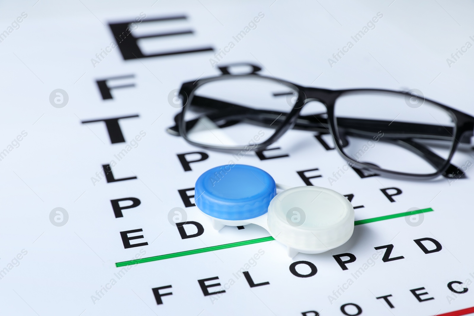 Glasses and lenses on vision test chart, closeup Photo of Glasses and lenses on vision test chart, closeup