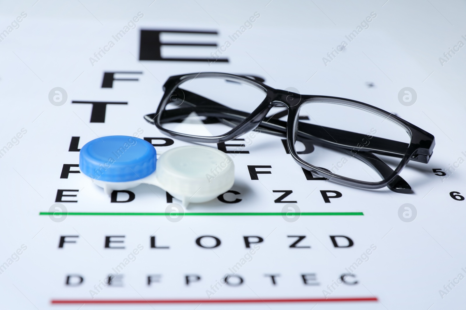 Glasses and lenses on vision test chart, closeup Photo of Glasses and lenses on vision test chart, closeup