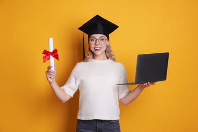 Photo of Happy student with diploma and laptop after graduation on orange background