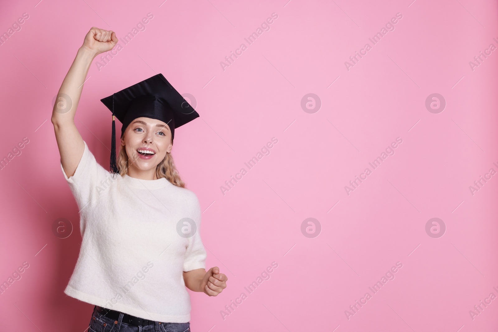 Photo of Happy student after graduation on pink background. Space for text