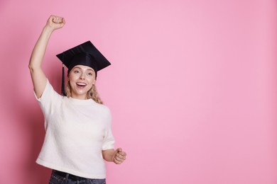Photo of Happy student after graduation on pink background. Space for text