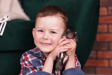 Photo of Little boy with his pet rat at home