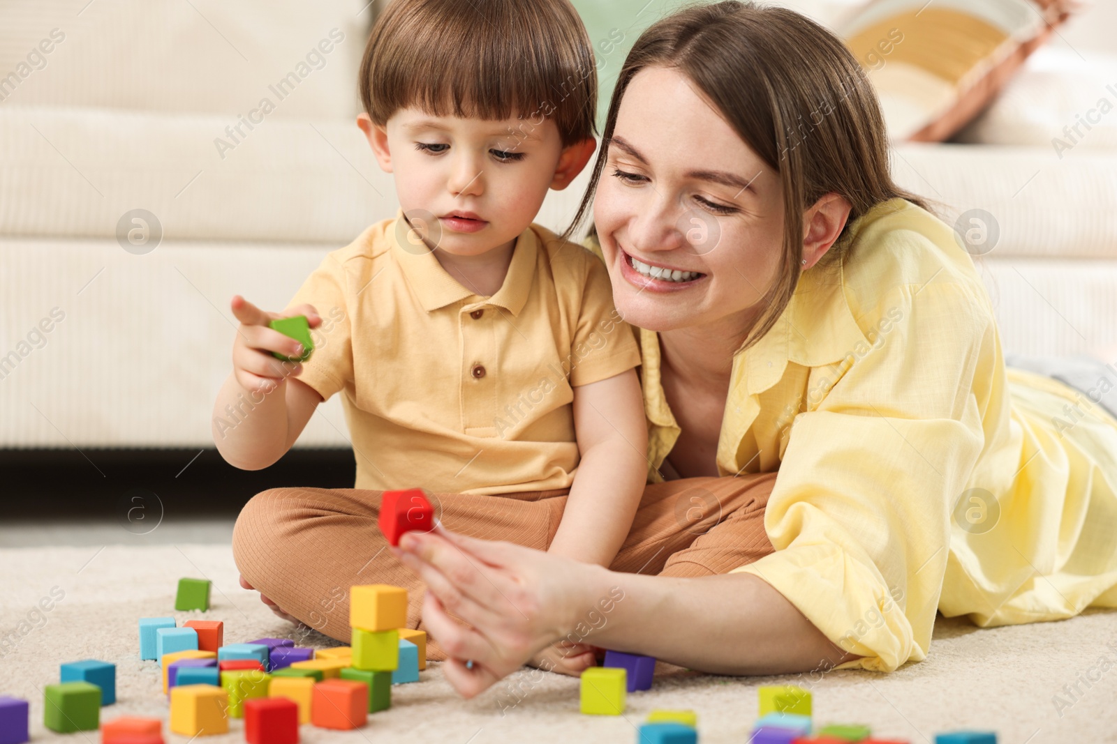 Mother and son playing with colorful cubes at home Photo of Mother and son playing with colorful cubes at home