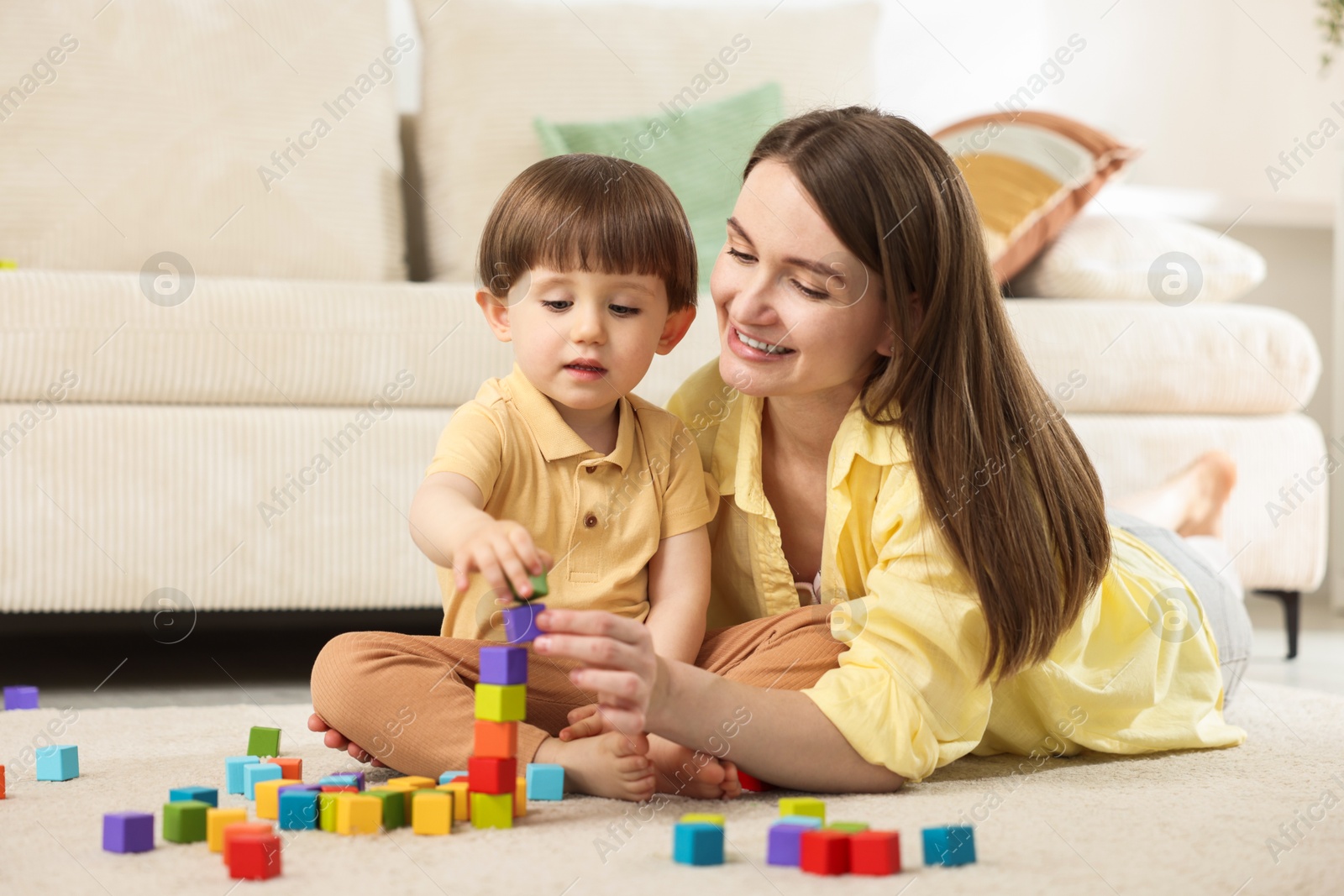 Mother and son playing with colorful cubes at home Photo of Mother and son playing with colorful cubes at home