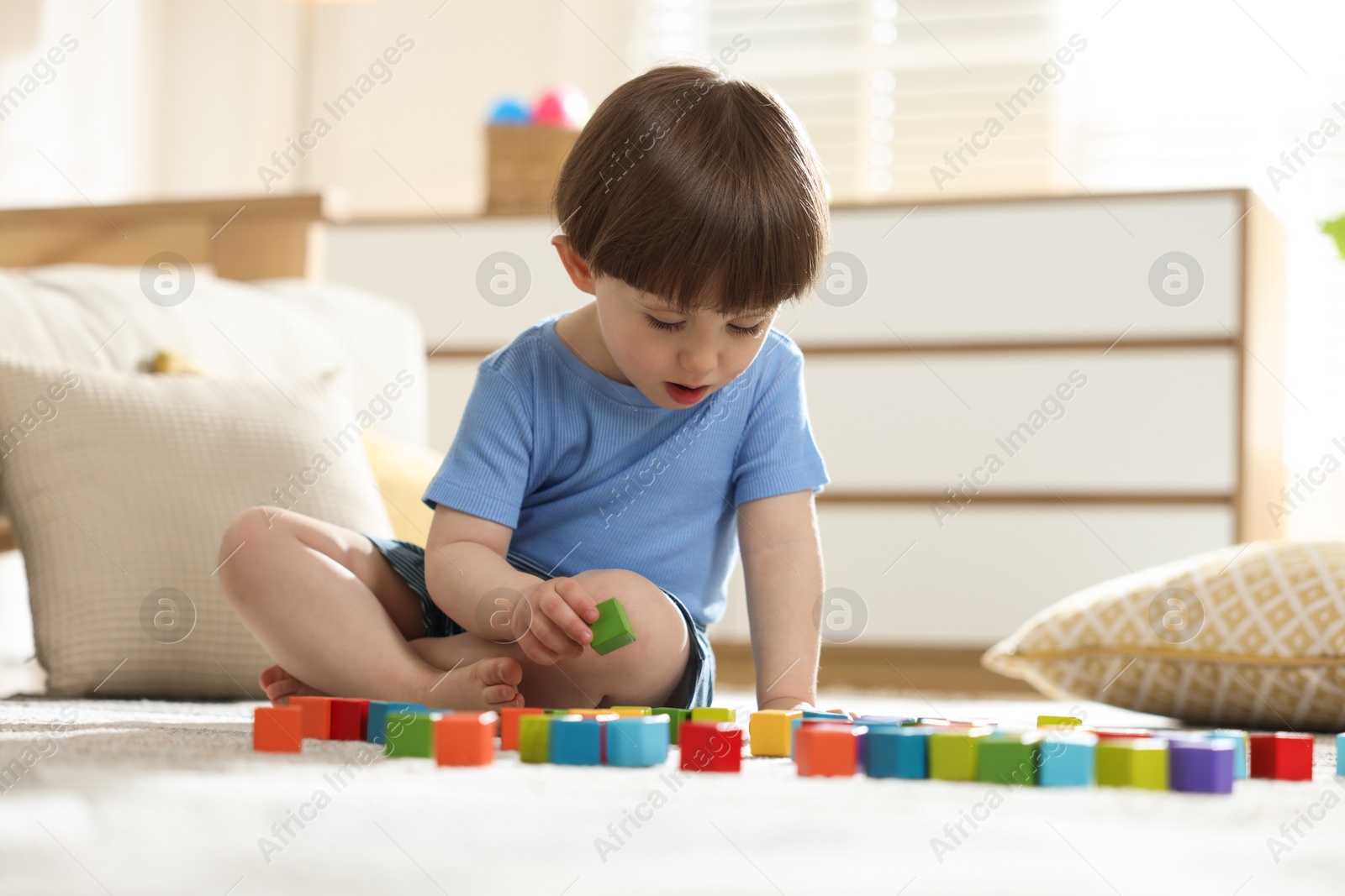 Cute little child playing with colorful cubes at home Photo of Cute little child playing with colorful cubes at home