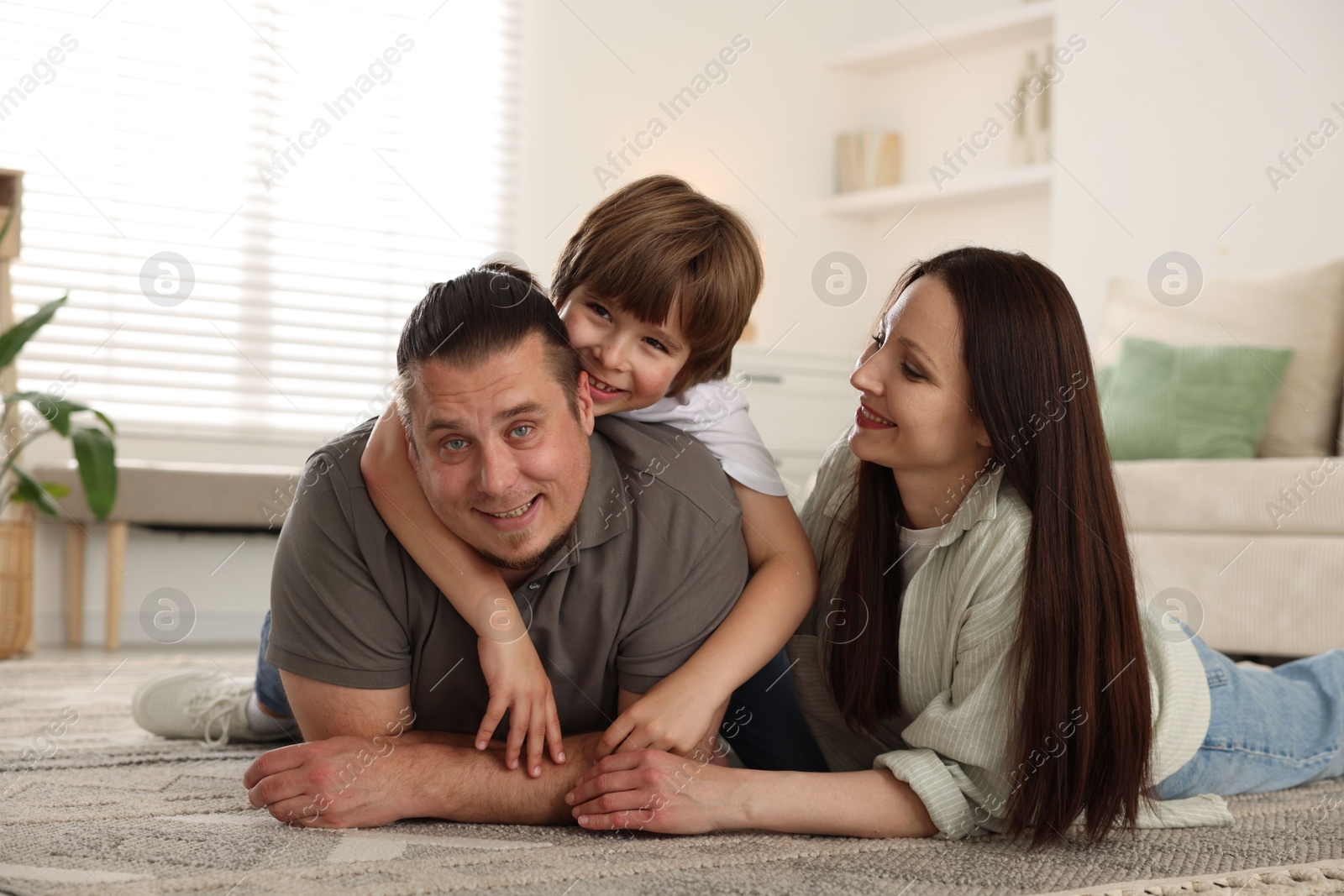 Parents with their son on floor at home Photo of Parents with their son on floor at home