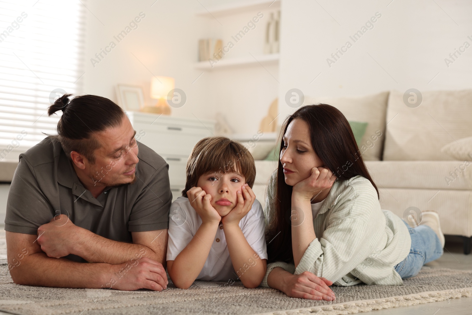 Parents with their son on floor at home Photo of Parents with their son on floor at home
