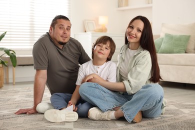 Photo of Parents with their son on floor at home