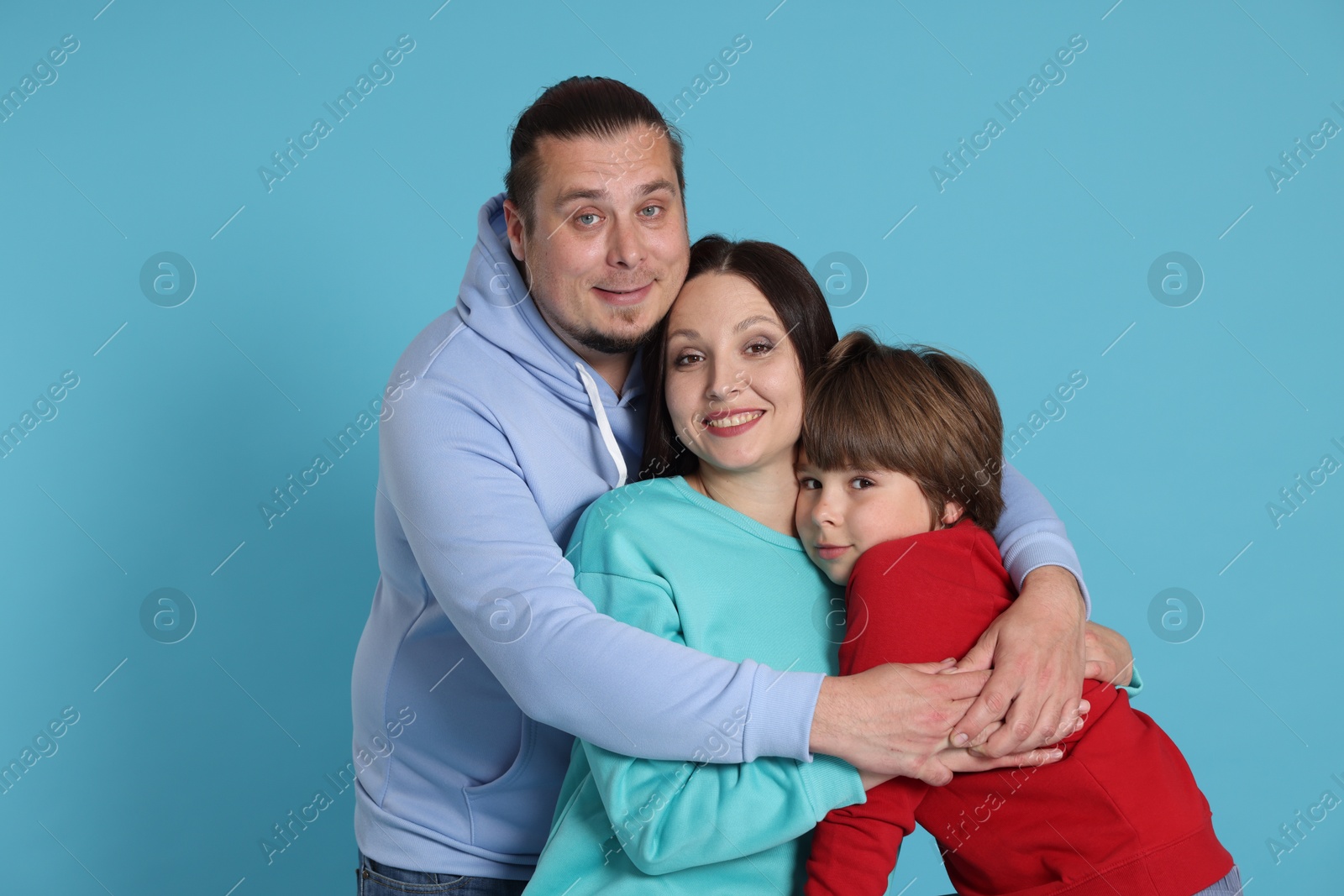 Portrait of happy family on light blue background Photo of Portrait of happy family on light blue background
