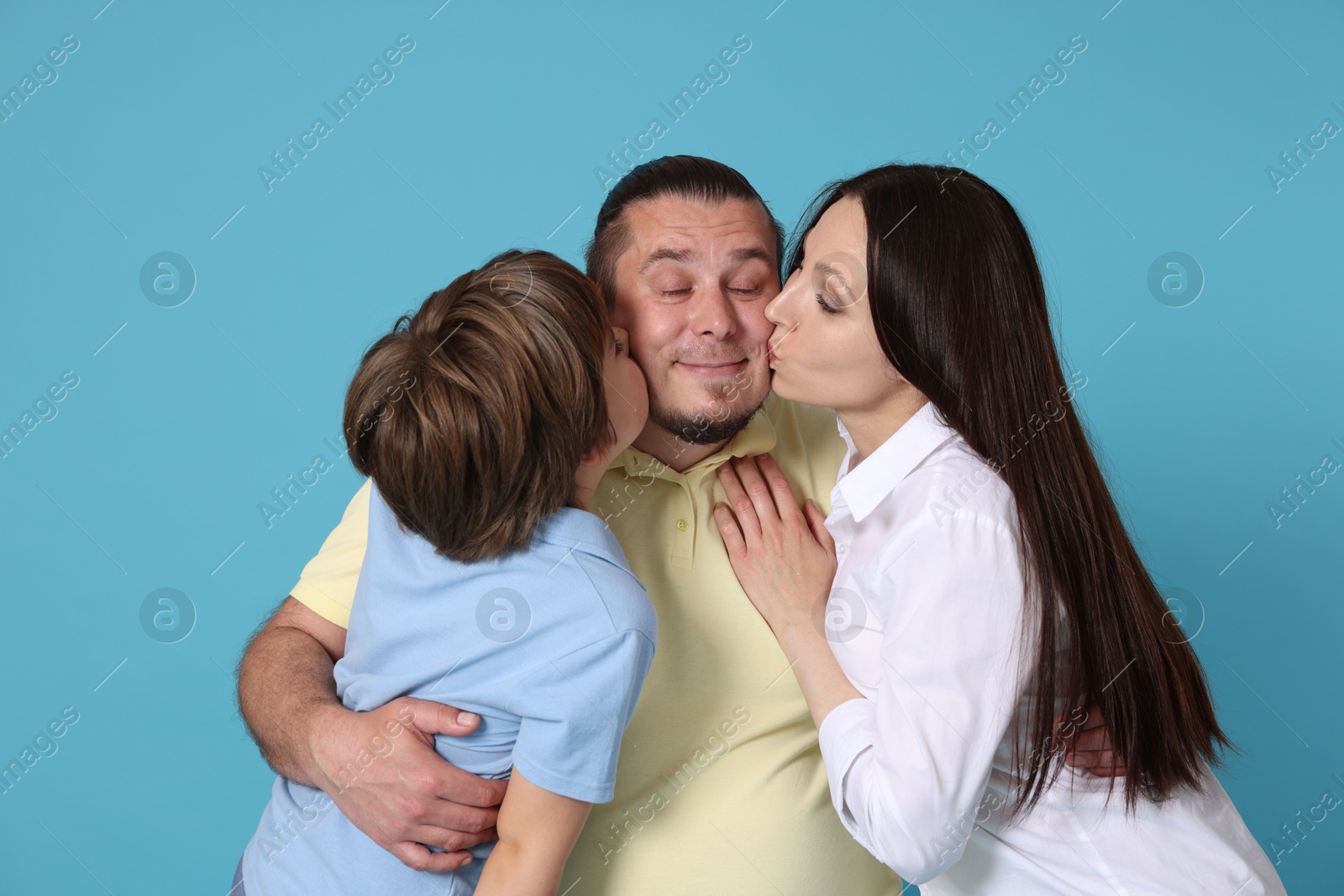 Portrait of happy family on light blue background Photo of Portrait of happy family on light blue background