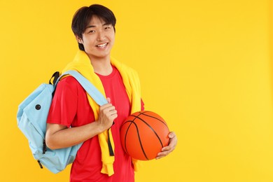 Photo of Student with basketball and backpack on orange background, space for text