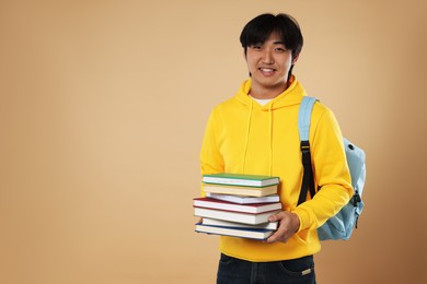 Photo of Student with books and backpack on beige background, space for text