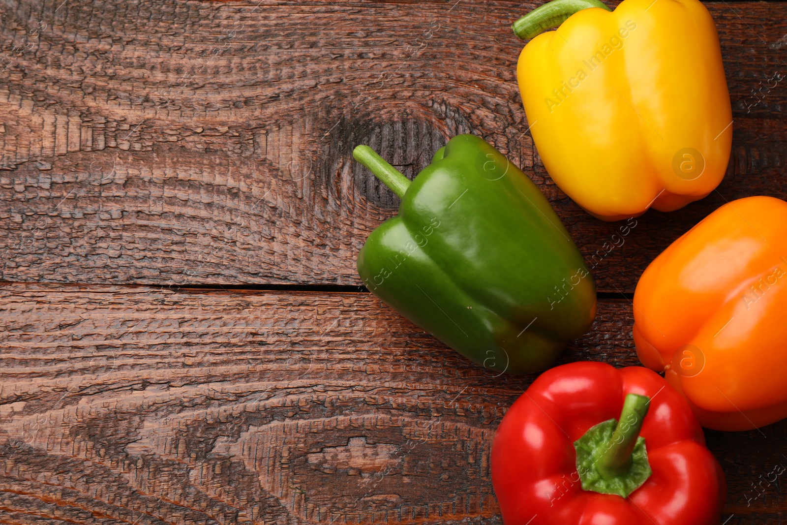 Fresh colorful bell peppers on wooden table, flat lay. Space for text Photo of Fresh colorful bell peppers on wooden table, flat lay. Space for text