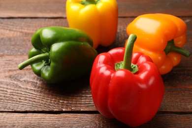 Photo of Fresh colorful bell peppers on wooden table, closeup