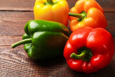 Photo of Fresh colorful bell peppers on wooden table, closeup