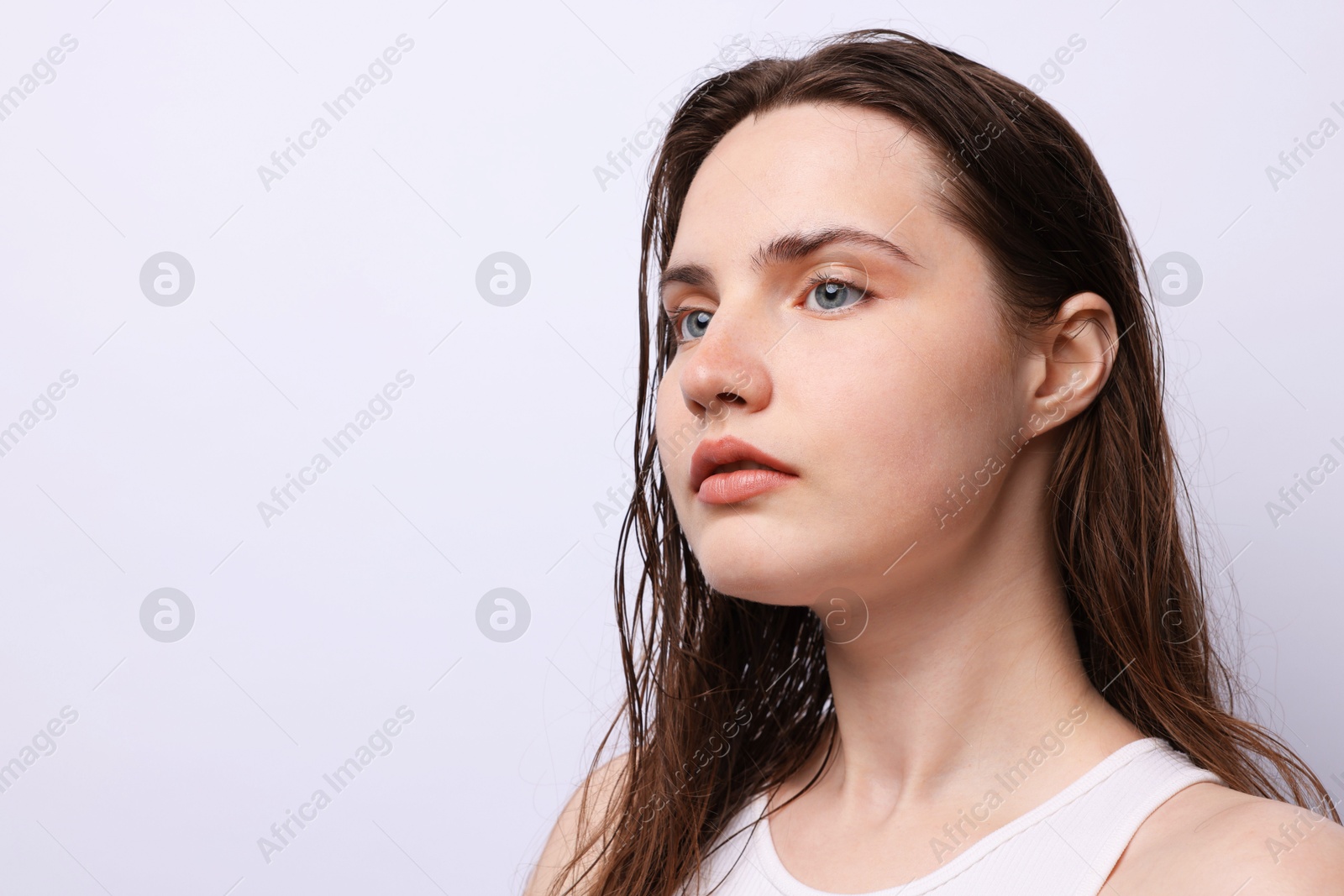 Photo of Beautiful woman with natural skin complexion on light grey background, closeup. Space for text