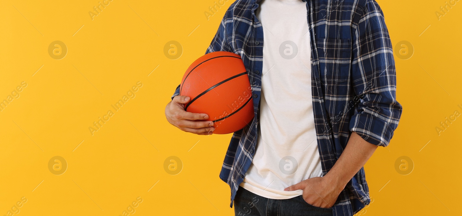 Student with basketball ball on orange background, closeup. Space for text Photo of Student with basketball ball on orange background, closeup. Space for text