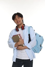 Photo of Student with headphones, books and backpack on white background
