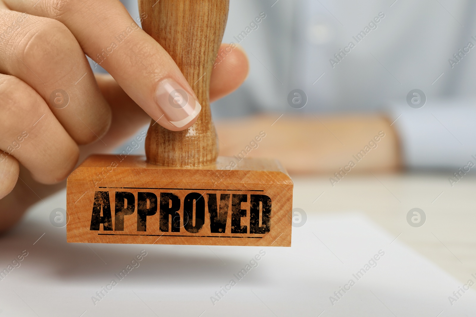 Approved. Woman stamping blank sheet of paper at table, closeup Image of Approved. Woman stamping blank sheet of paper at table, closeup