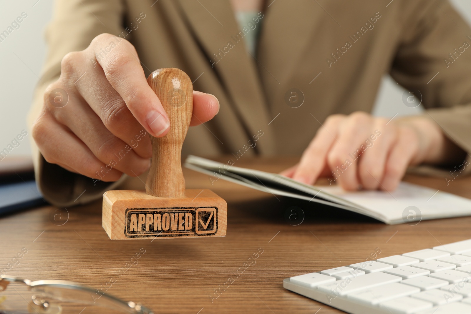 Approved. Woman stamping passport at table, closeup Image of Approved. Woman stamping passport at table, closeup