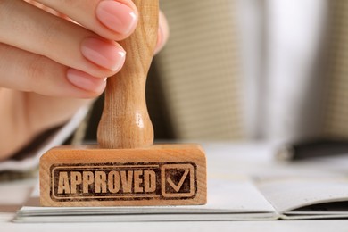 Image of Approved. Woman stamping passport at table, closeup
