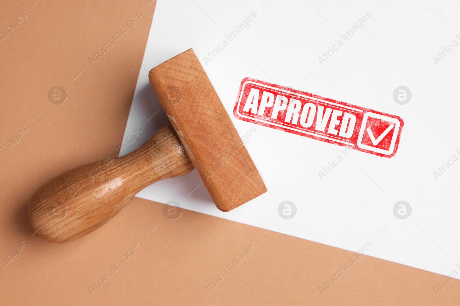 Sheet of paper with red stamp Approved and wooden stamp on pale brown background Image of Sheet of paper with red stamp Approved and wooden stamp on pale brown background