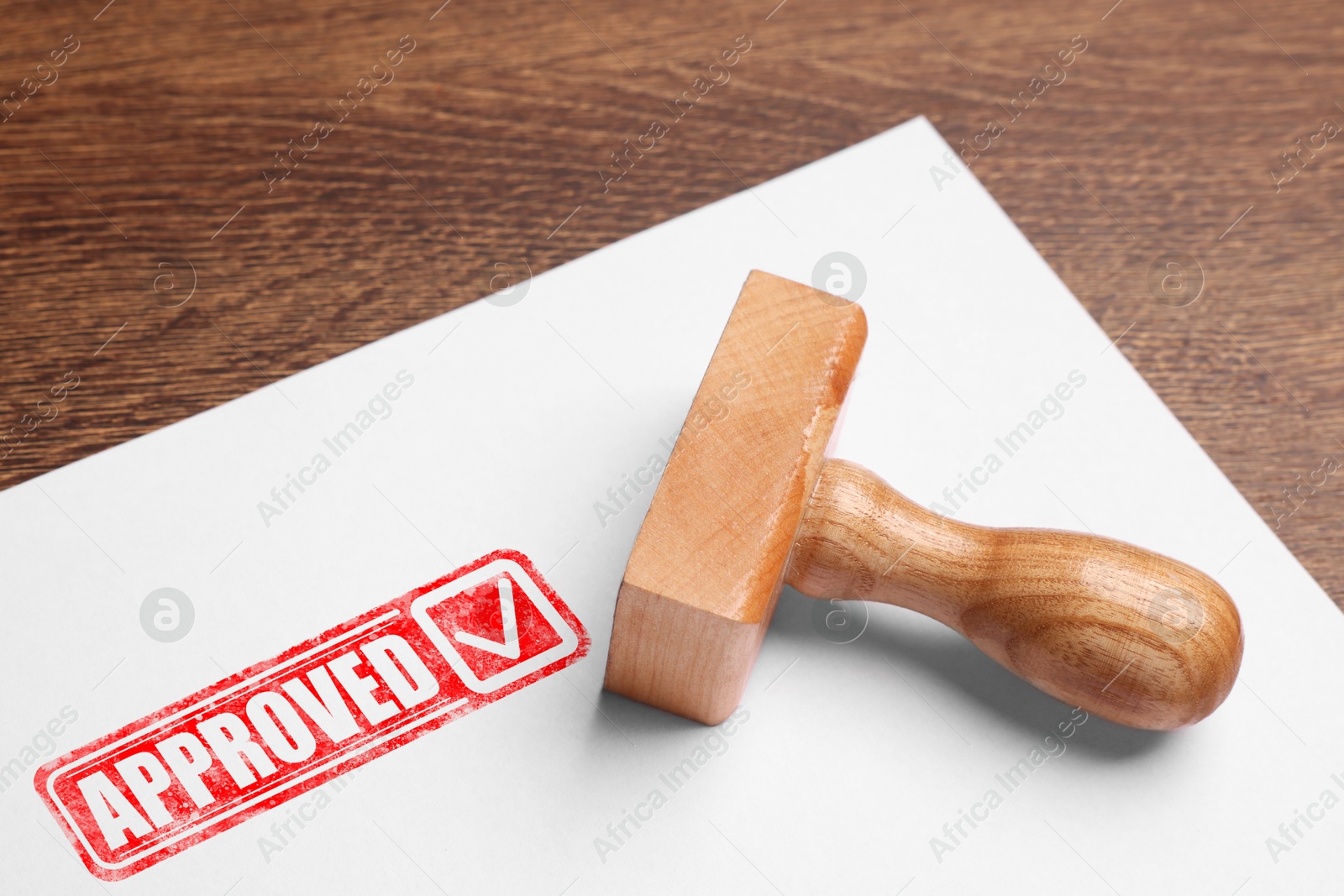 Sheet of paper with red stamp Approved and wooden stamp on table Image of Sheet of paper with red stamp Approved and wooden stamp on table