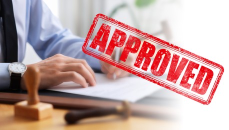 Image of Man signing document at table in office and red stamp Approved, banner design