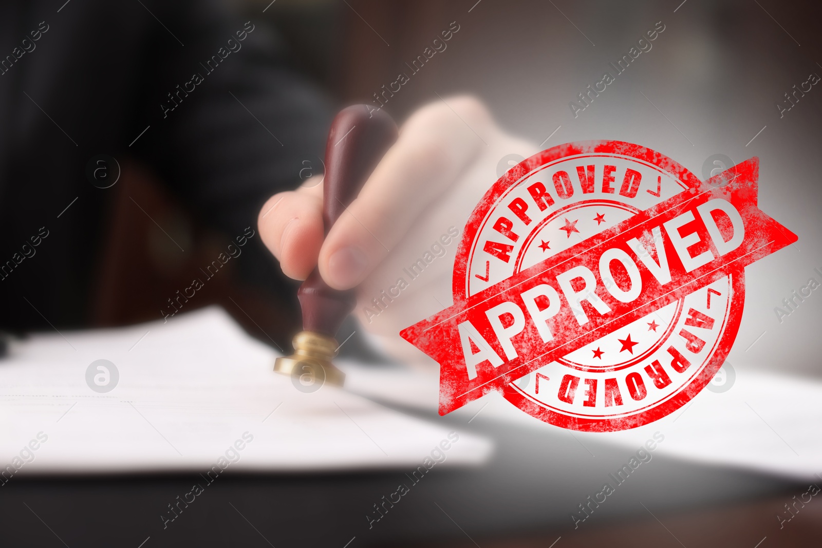 Man stamping document at table and red stamp Approved Image of Man stamping document at table and red stamp Approved
