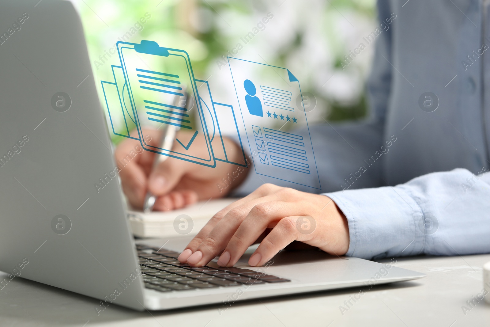 Human resources manager working on laptop at table, closeup. Candidate's resume on virtual screen above computer. Recruitment and employee search Image of Human resources manager working on laptop at table, closeup. Candidate's resume on virtual screen above computer. Recruitment and employee search