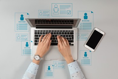 Image of Human resources manager searching for employee on laptop at table, top view. Virtual resumes around computer. Recruitment