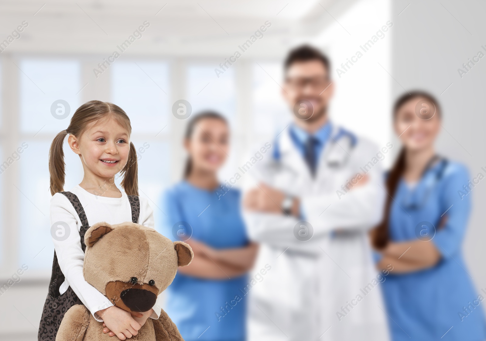Image of Cute child holding toy bear and medical staff in hospital. Pediatric ward