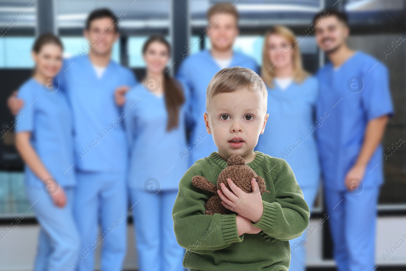 Image of Cute child holding toy bear and medical staff in hospital. Pediatric ward