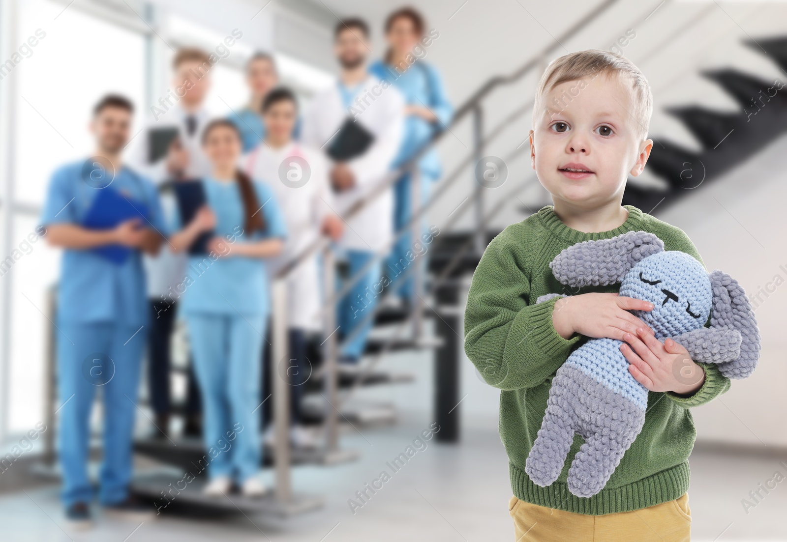 Cute child holding toy bunny and medical staff in hospital. Pediatric ward Image of Cute child holding toy bunny and medical staff in hospital. Pediatric ward