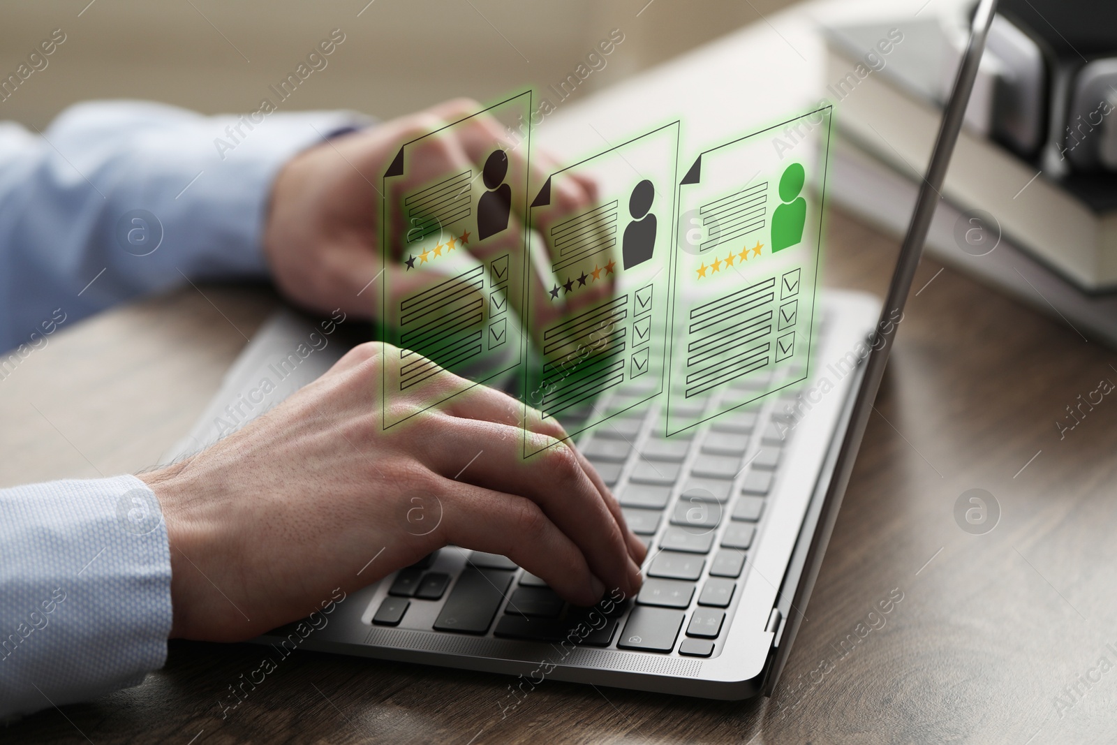 Human resources manager searching for employee on laptop at table, closeup. Resumes on virtual screen above computer. Recruitment Image of Human resources manager searching for employee on laptop at table, closeup. Resumes on virtual screen above computer. Recruitment