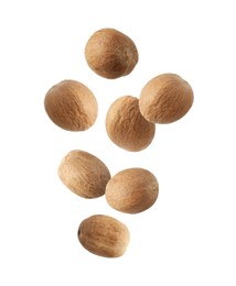 Image of Aromatic nutmeg seeds falling on white background